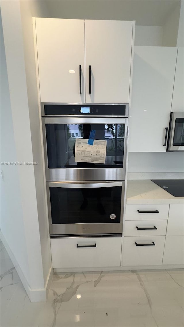 details featuring white cabinetry, light stone counters, and stainless steel appliances