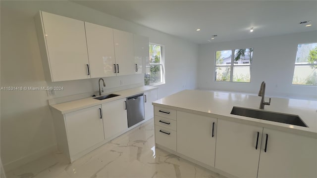 kitchen featuring dishwasher, sink, a wealth of natural light, and white cabinets