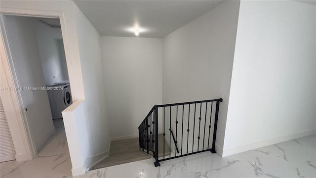 staircase with washer / dryer and light tile floors