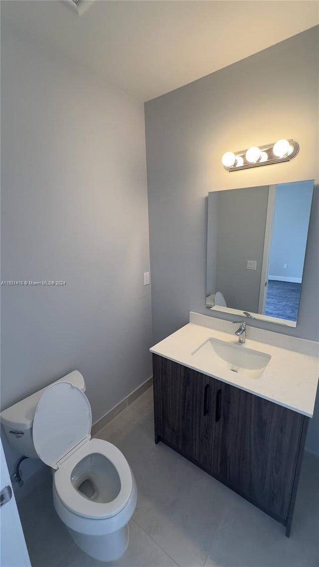 bathroom with tile flooring, vanity, and toilet