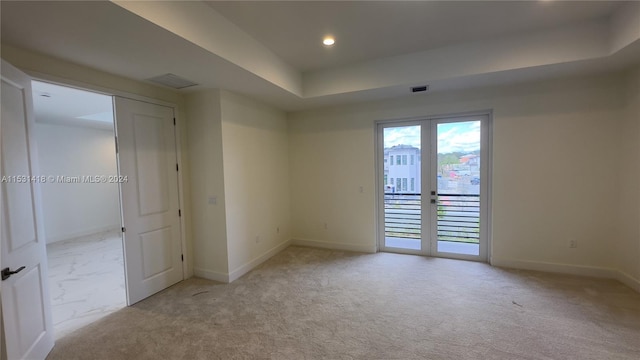 carpeted spare room featuring french doors