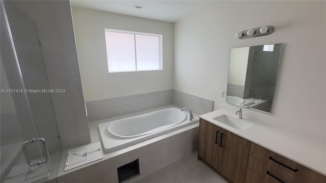 bathroom with shower with separate bathtub and vanity with extensive cabinet space