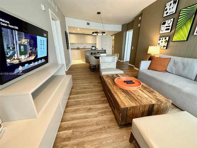 living room with light hardwood / wood-style floors and an inviting chandelier