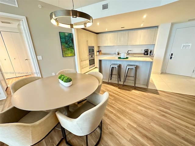 dining room with sink and light wood-type flooring