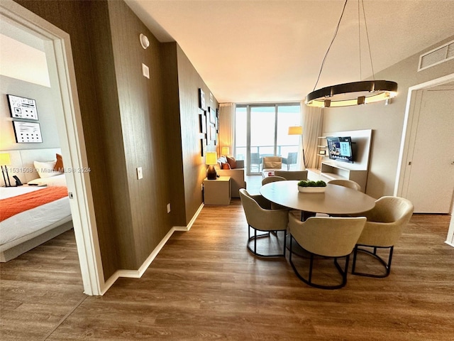 dining room with a notable chandelier, floor to ceiling windows, and dark wood-type flooring