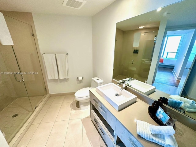 bathroom with an enclosed shower, oversized vanity, toilet, and tile flooring