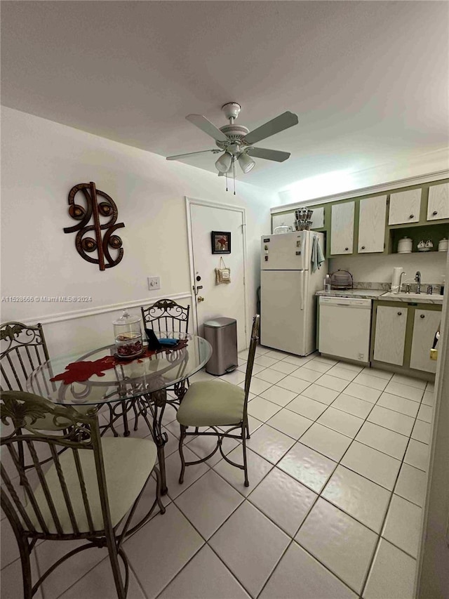 tiled dining room with ceiling fan and sink