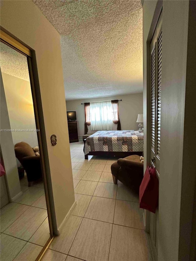 bedroom with a textured ceiling and light tile patterned floors