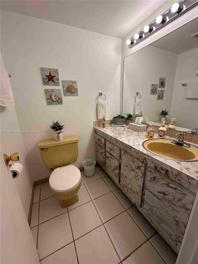 bathroom featuring tile patterned flooring, vanity, and toilet