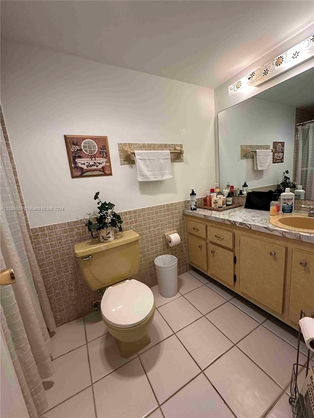 bathroom with vanity, tile walls, tile patterned flooring, and toilet