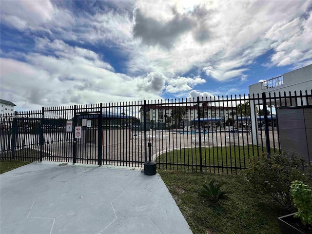 view of gate with a lawn