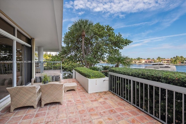 view of patio featuring a balcony and a water view