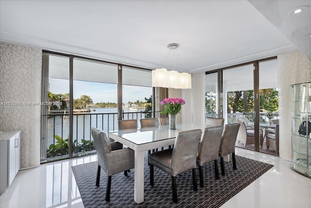 tiled dining area featuring a wall of windows, a water view, and a wealth of natural light