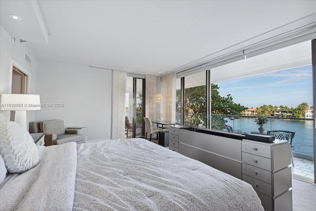 carpeted bedroom with a water view