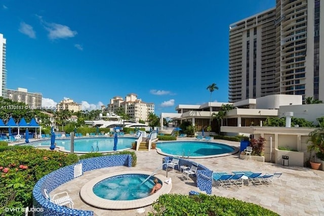 view of pool with a patio and a hot tub