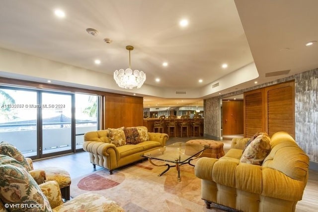 living room with an inviting chandelier and light hardwood / wood-style floors