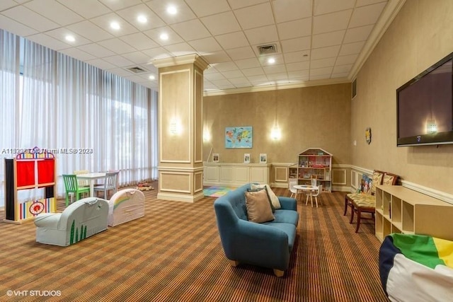 interior space featuring dark colored carpet, crown molding, and ornate columns