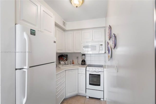 kitchen with white appliances, sink, light tile floors, tasteful backsplash, and white cabinetry