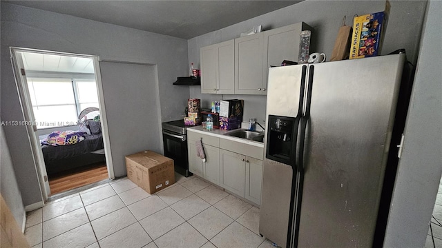 kitchen with light tile floors, white cabinetry, stainless steel refrigerator with ice dispenser, electric range oven, and sink