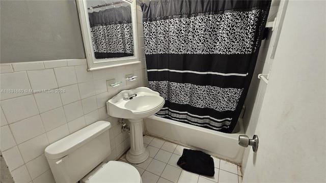 bathroom featuring tile floors, toilet, and tile walls