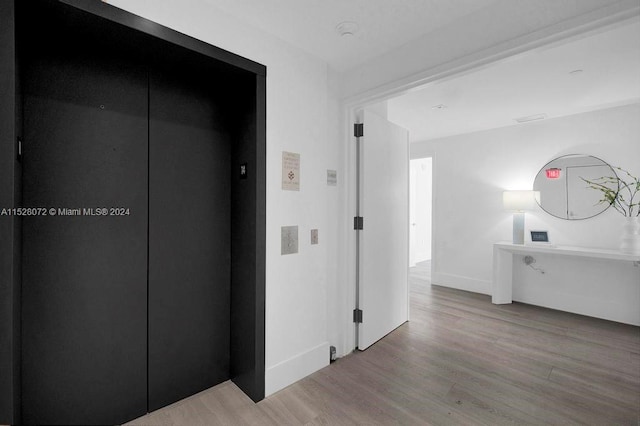 corridor featuring elevator and light wood-type flooring