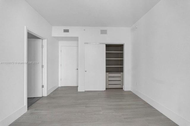 unfurnished bedroom featuring a closet and light hardwood / wood-style flooring