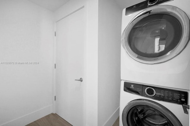 washroom featuring stacked washing maching and dryer and hardwood / wood-style flooring