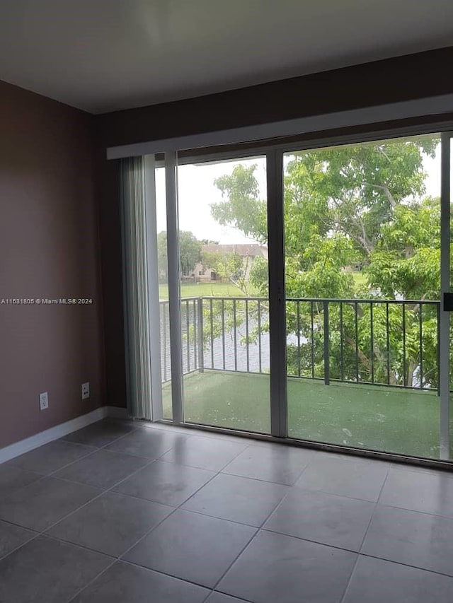 doorway featuring dark tile flooring and a wealth of natural light