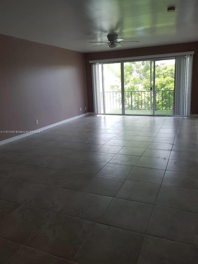 unfurnished room with dark tile floors and ceiling fan