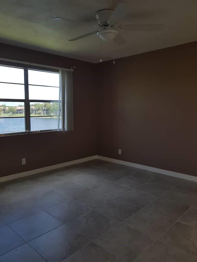 tiled spare room with ceiling fan