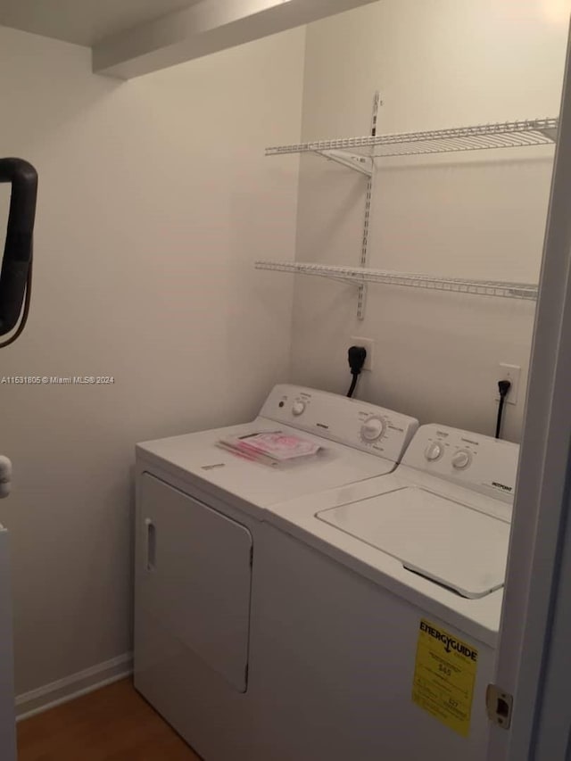 clothes washing area featuring washer and clothes dryer, hookup for an electric dryer, and dark wood-type flooring