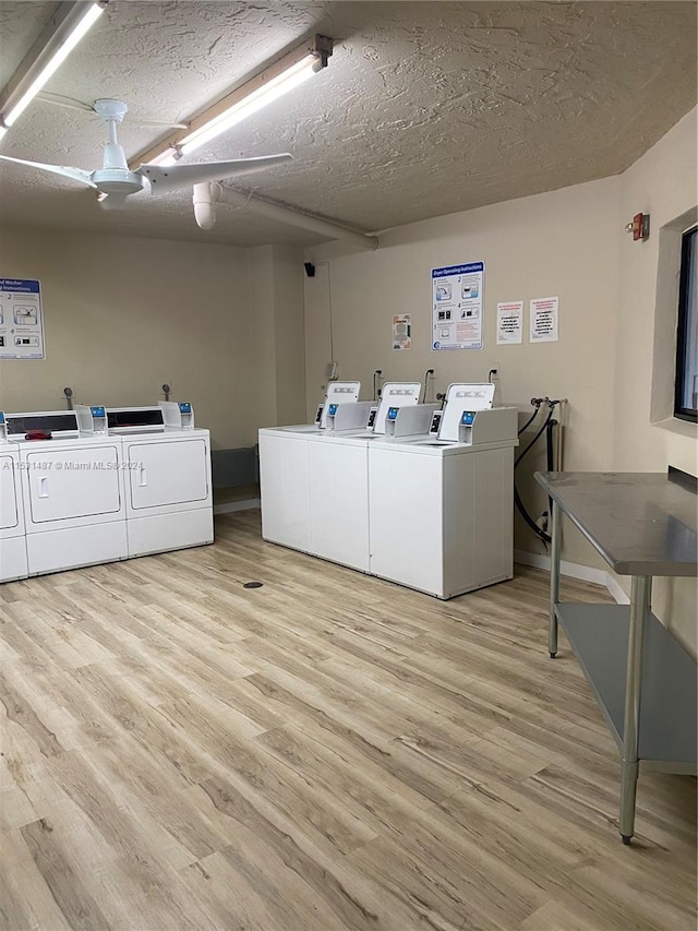 laundry area featuring a textured ceiling, washer and dryer, and light hardwood / wood-style flooring