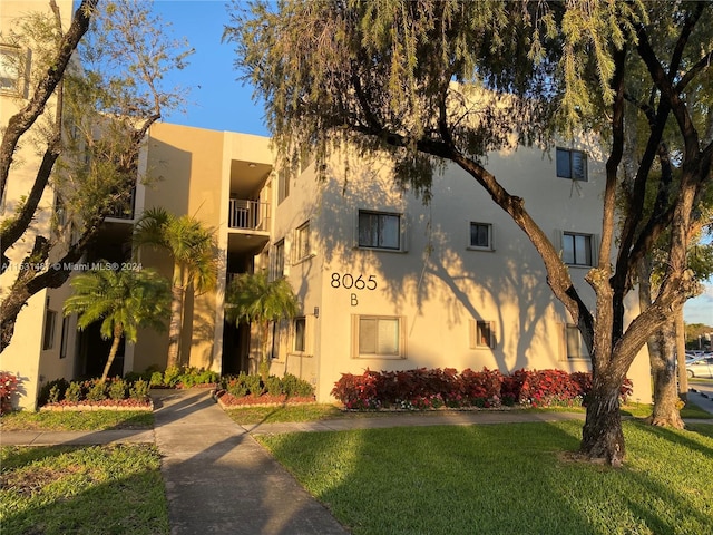 view of front of house with a balcony and a front lawn