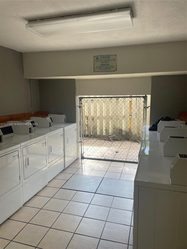 clothes washing area with light tile flooring and washer and clothes dryer