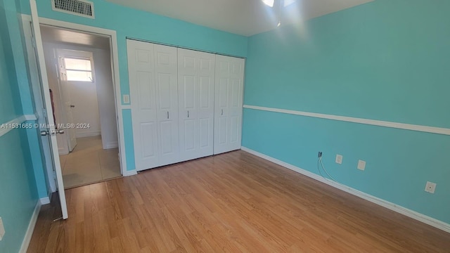 unfurnished bedroom with light hardwood / wood-style floors and a closet