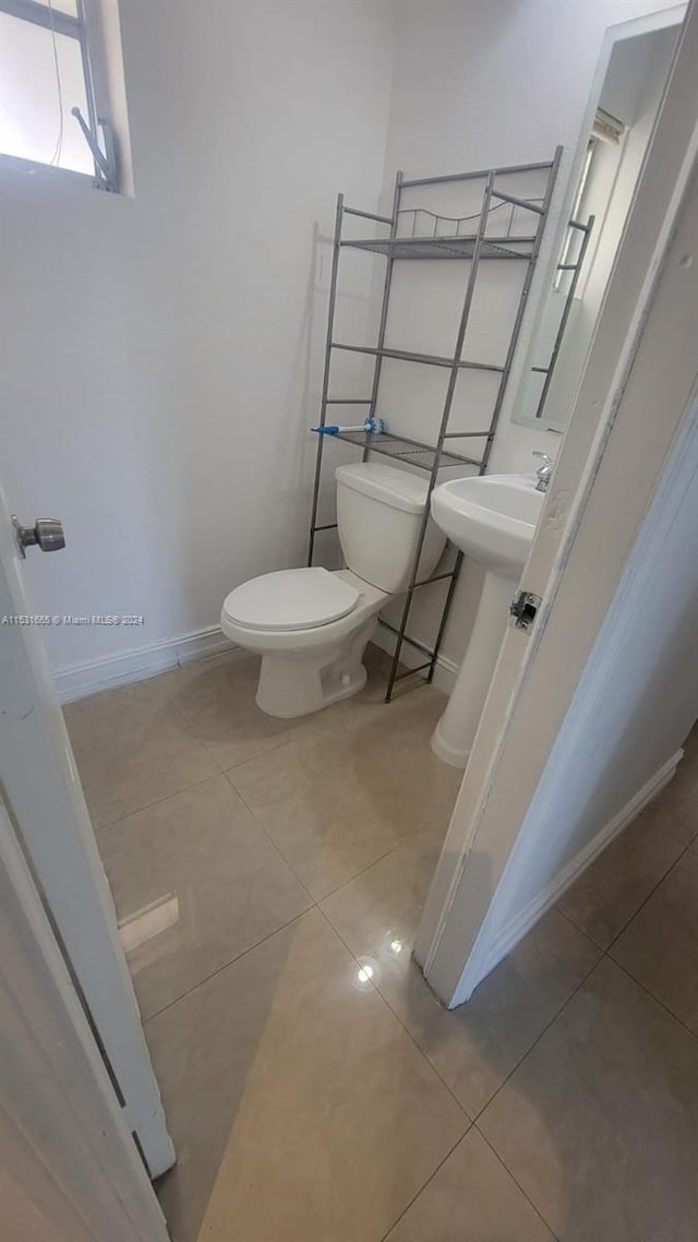 bathroom featuring toilet and tile floors