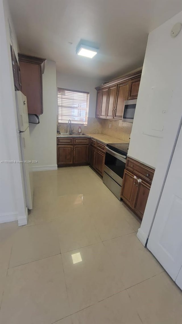 kitchen with dark brown cabinetry, sink, appliances with stainless steel finishes, and tasteful backsplash