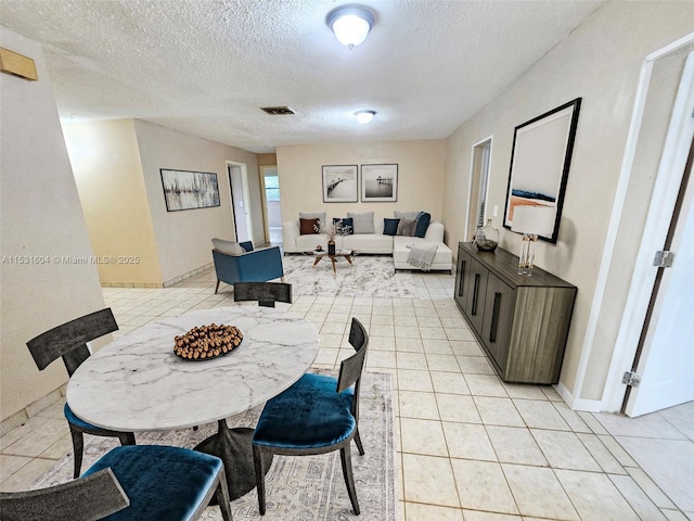 tiled dining room featuring a textured ceiling