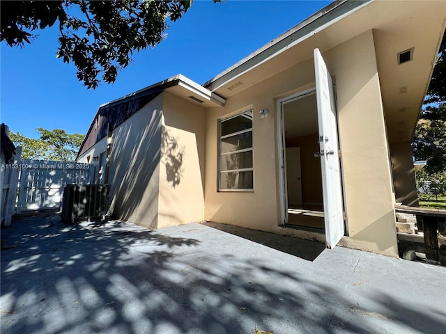 view of exterior entry with a patio area