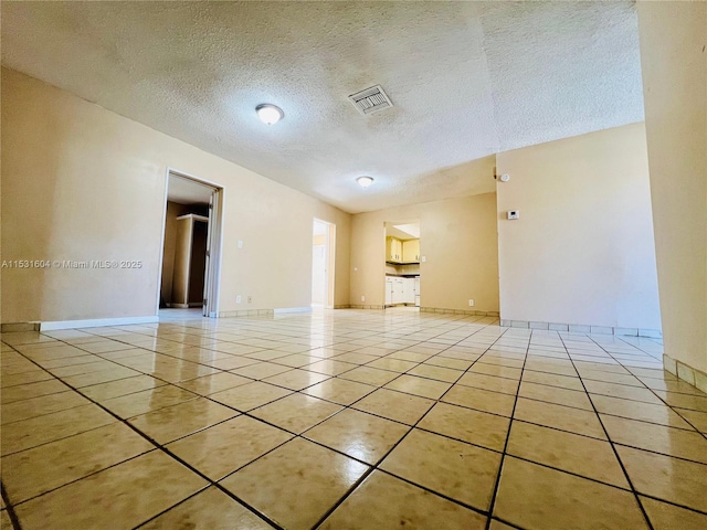 tiled spare room with a textured ceiling