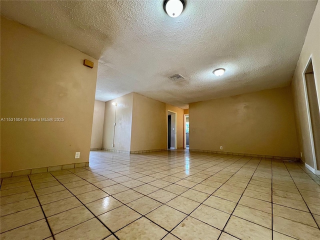 tiled spare room with a textured ceiling