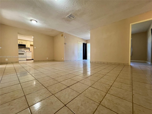 unfurnished room featuring light tile patterned floors and a textured ceiling