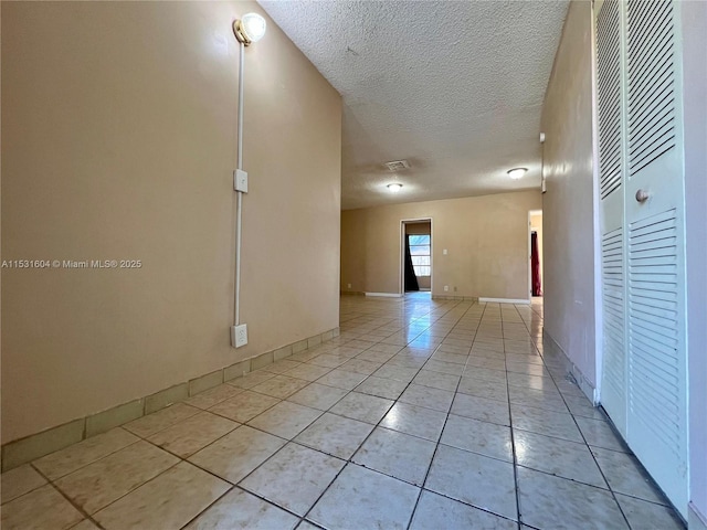 spare room with light tile patterned floors and a textured ceiling