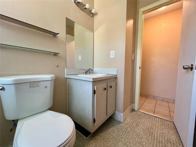 bathroom with tile patterned flooring, vanity, and toilet