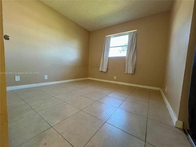 tiled spare room featuring a textured ceiling