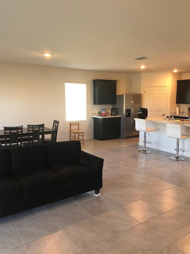 living room with light tile floors and sink