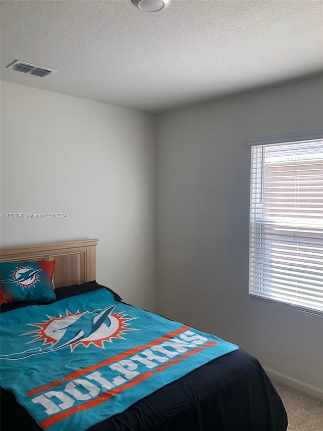 bedroom featuring a textured ceiling and carpet