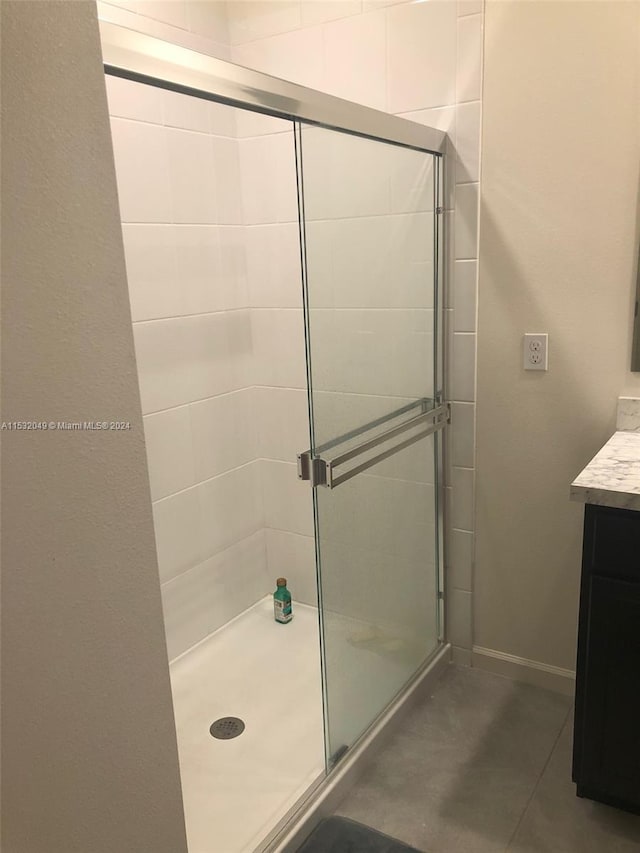 bathroom with a shower with door and vanity