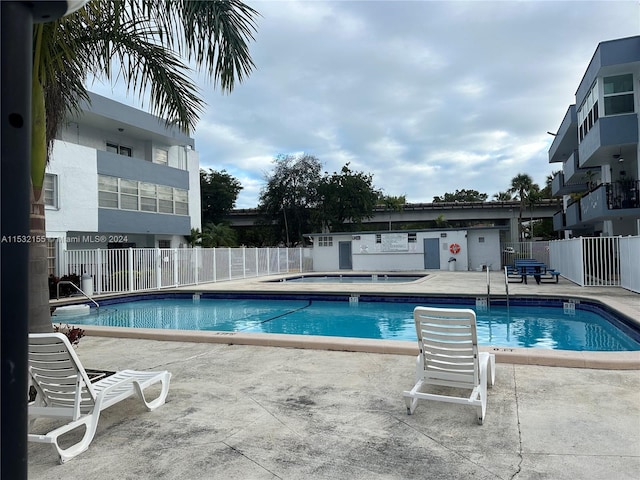 view of swimming pool featuring a community hot tub and a patio area