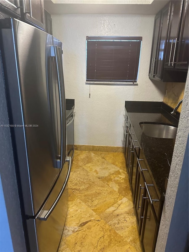 kitchen featuring sink, stainless steel fridge, and dark brown cabinets